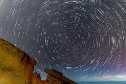 Startrails mit Felsen über dem Atlantik