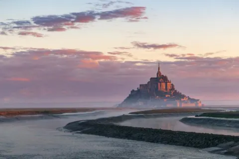 Le Mont Saint Michel in the morning fog at sunrise