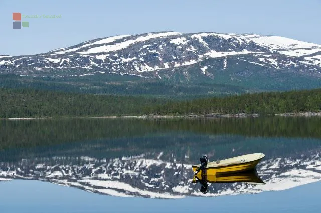 3. Platz im Geo Wettbewerb 2009 zu dem Thema "Ihr Paradies" mit dem Foto: Boot, Berge und See.