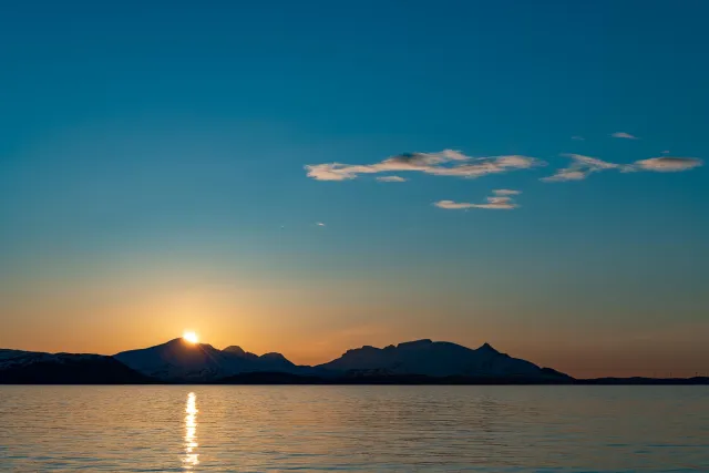 The midnight sun over the island of Reinøya in the Ullsfjord in Norway