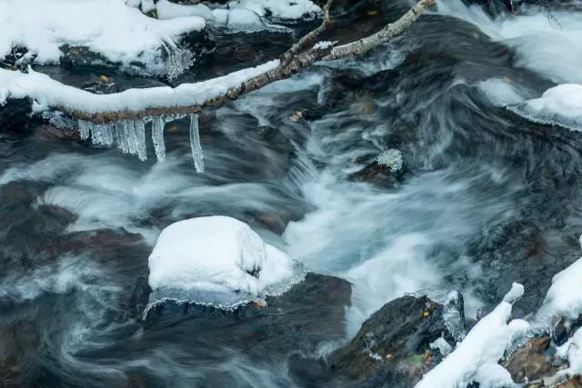 Eiszapfen über kleinem Bach in Andorra